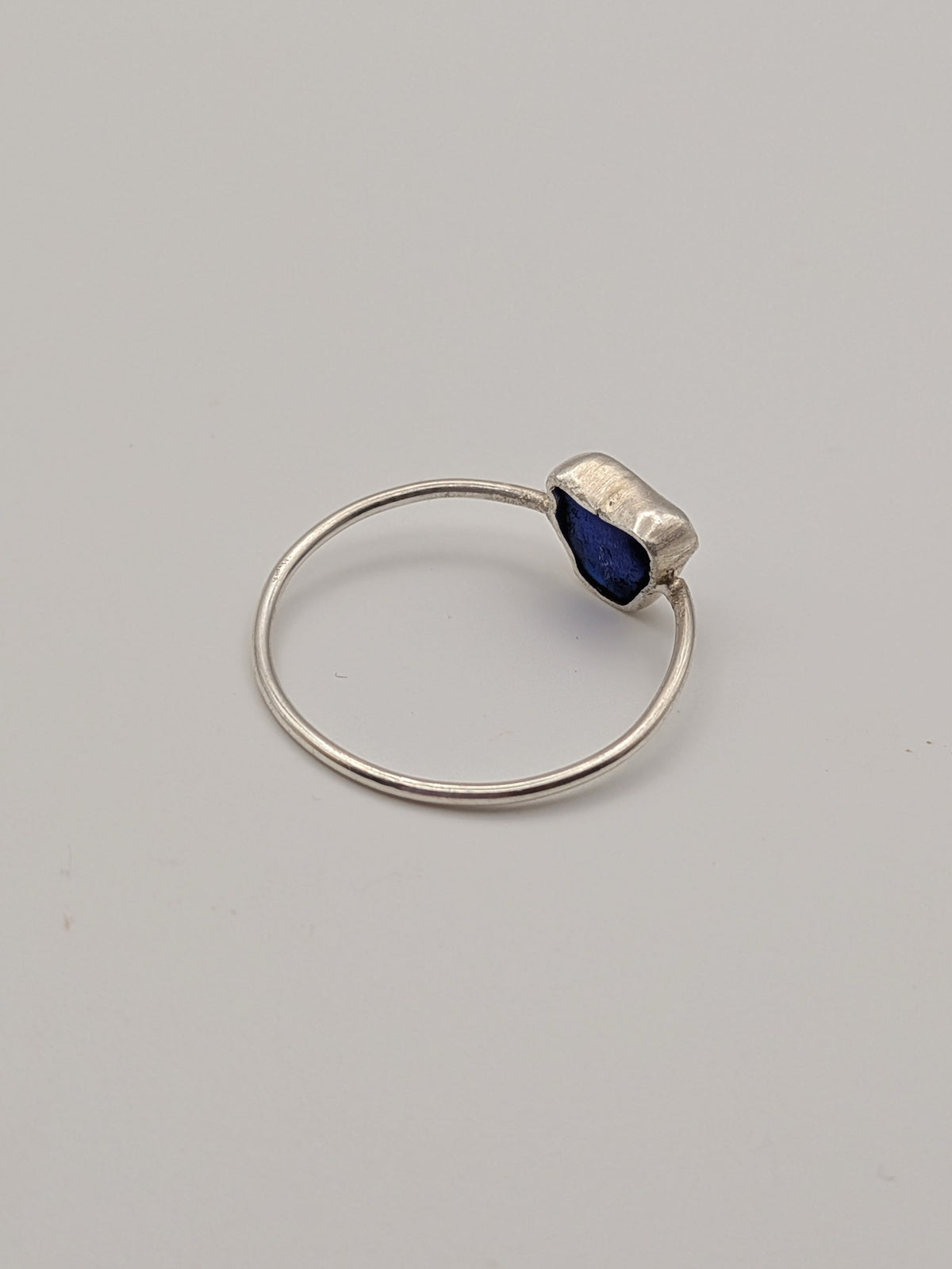 Blue sea glass ring in a handmade sterling silver setting with a fine silver bezel by All Our Light.