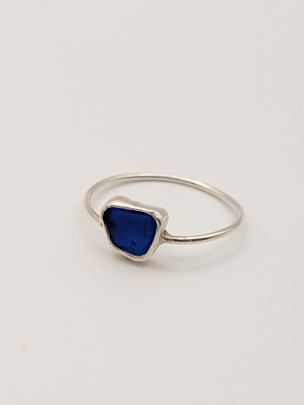 Blue sea glass ring in a handmade sterling silver setting with a fine silver bezel by All Our Light.