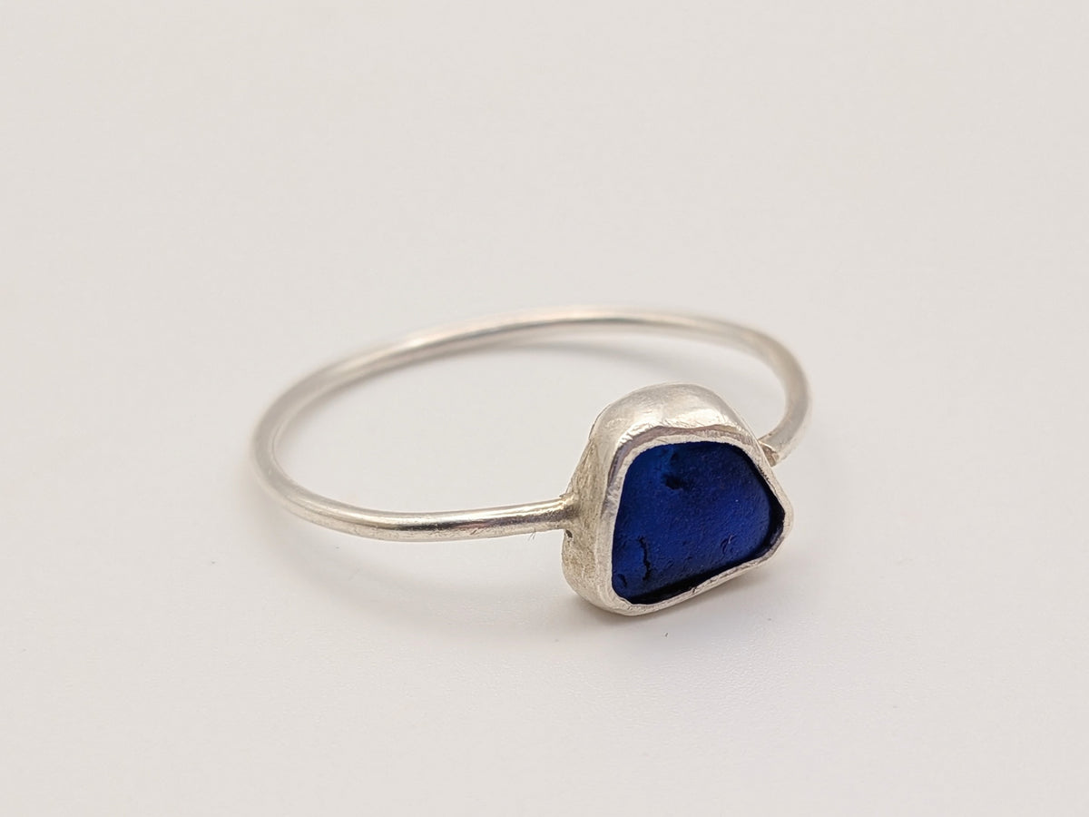 Blue sea glass ring in a handmade sterling silver setting with a fine silver bezel by All Our Light.