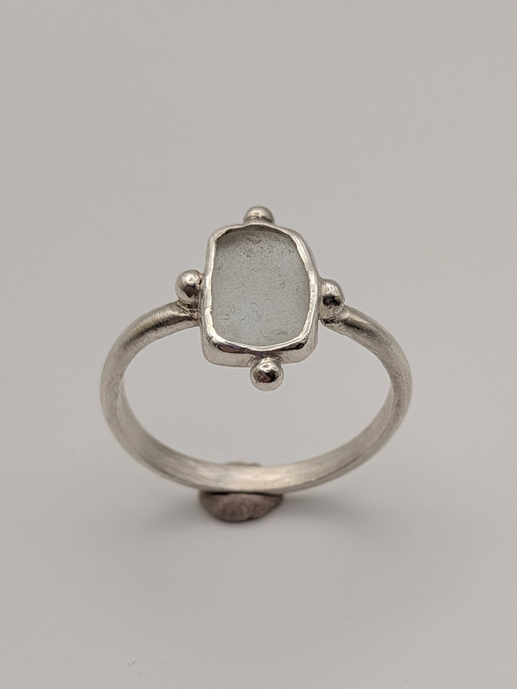 Clear sea glass bubble ring in a handmade sterling silver setting with a fine silver bezel by All Our Light.