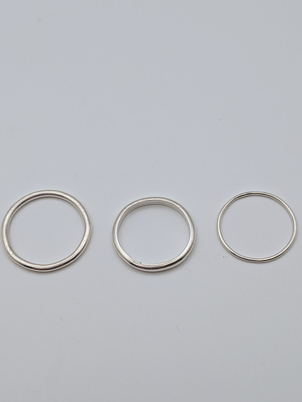 Handmade sterling silver stacking rings in round wire and D-profile designs by All Our Light.