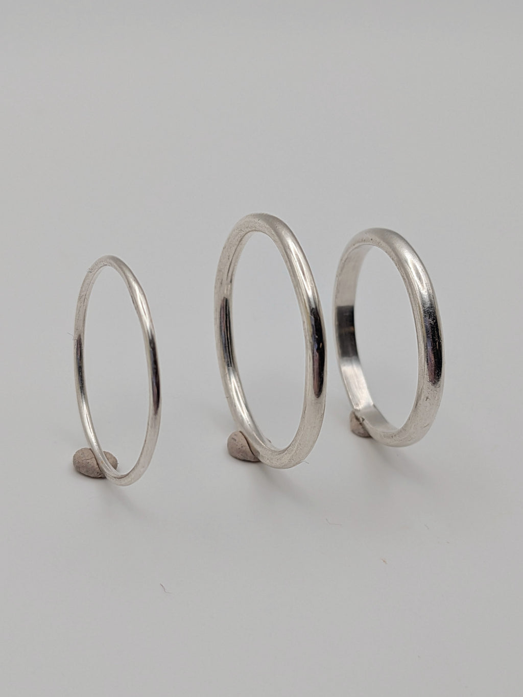 Handmade sterling silver stacking rings in round wire and D-profile designs by All Our Light.