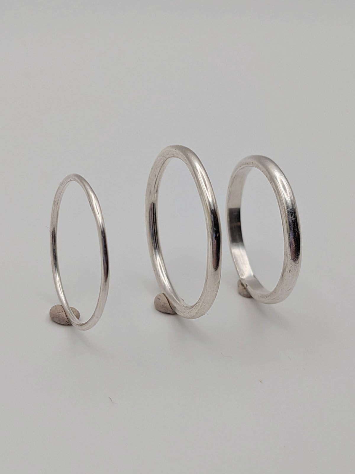 Handmade sterling silver stacking rings in round wire and D-profile designs by All Our Light.