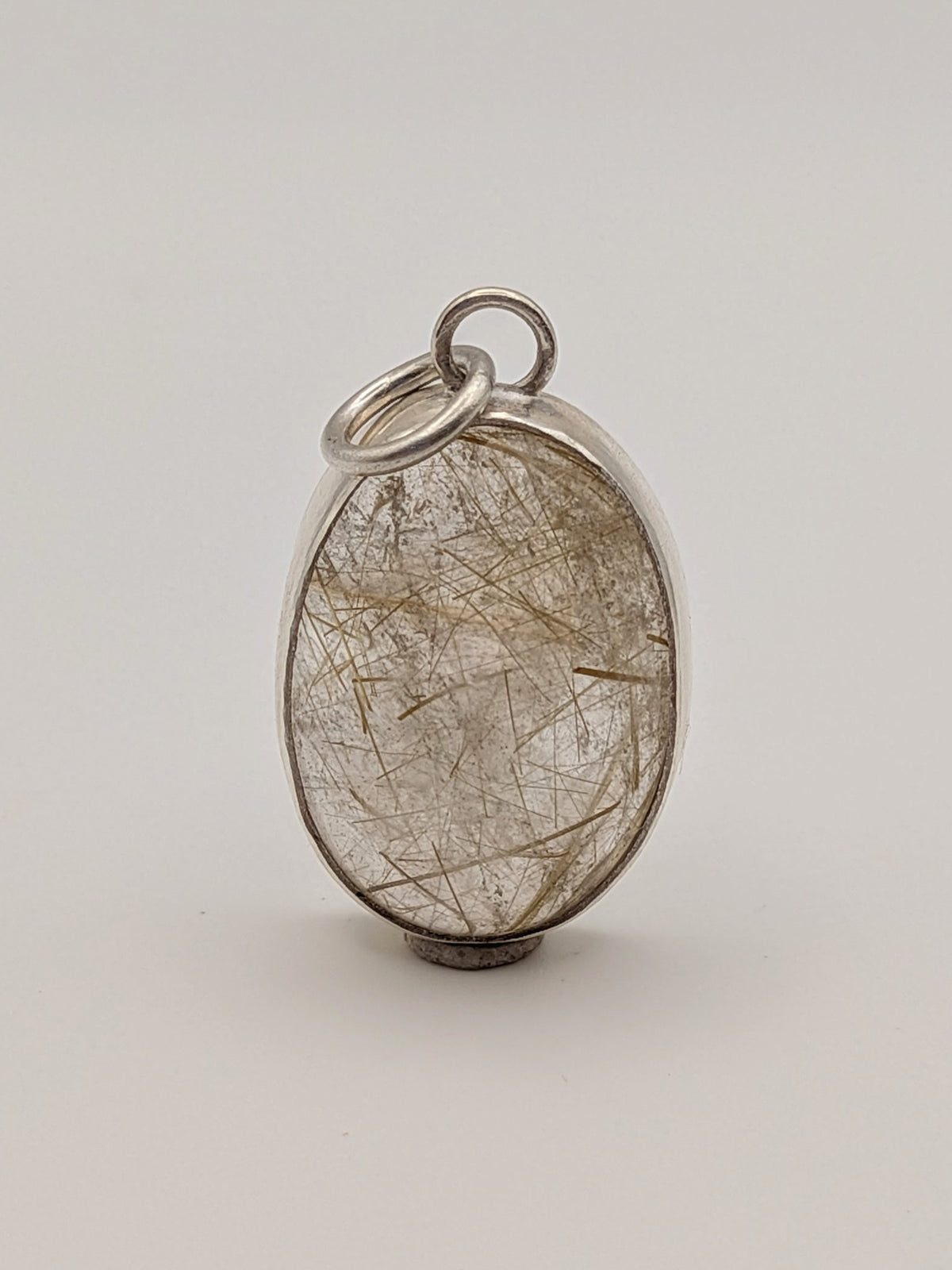 Rutilated quartz pendant in a handmade sterling silver setting by All Our Light.