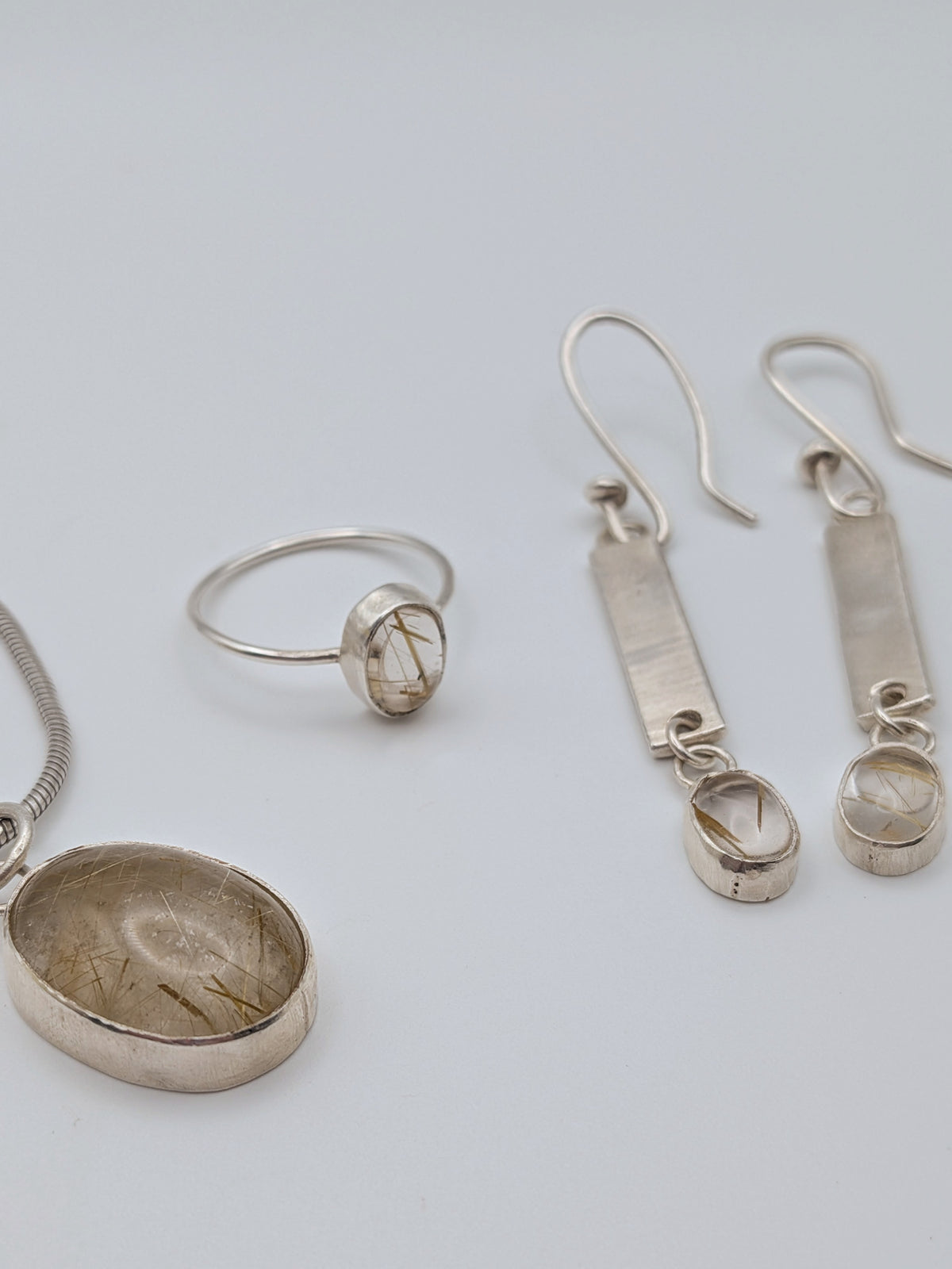 Rutilated quartz pendant in a handmade sterling silver setting by All Our Light.