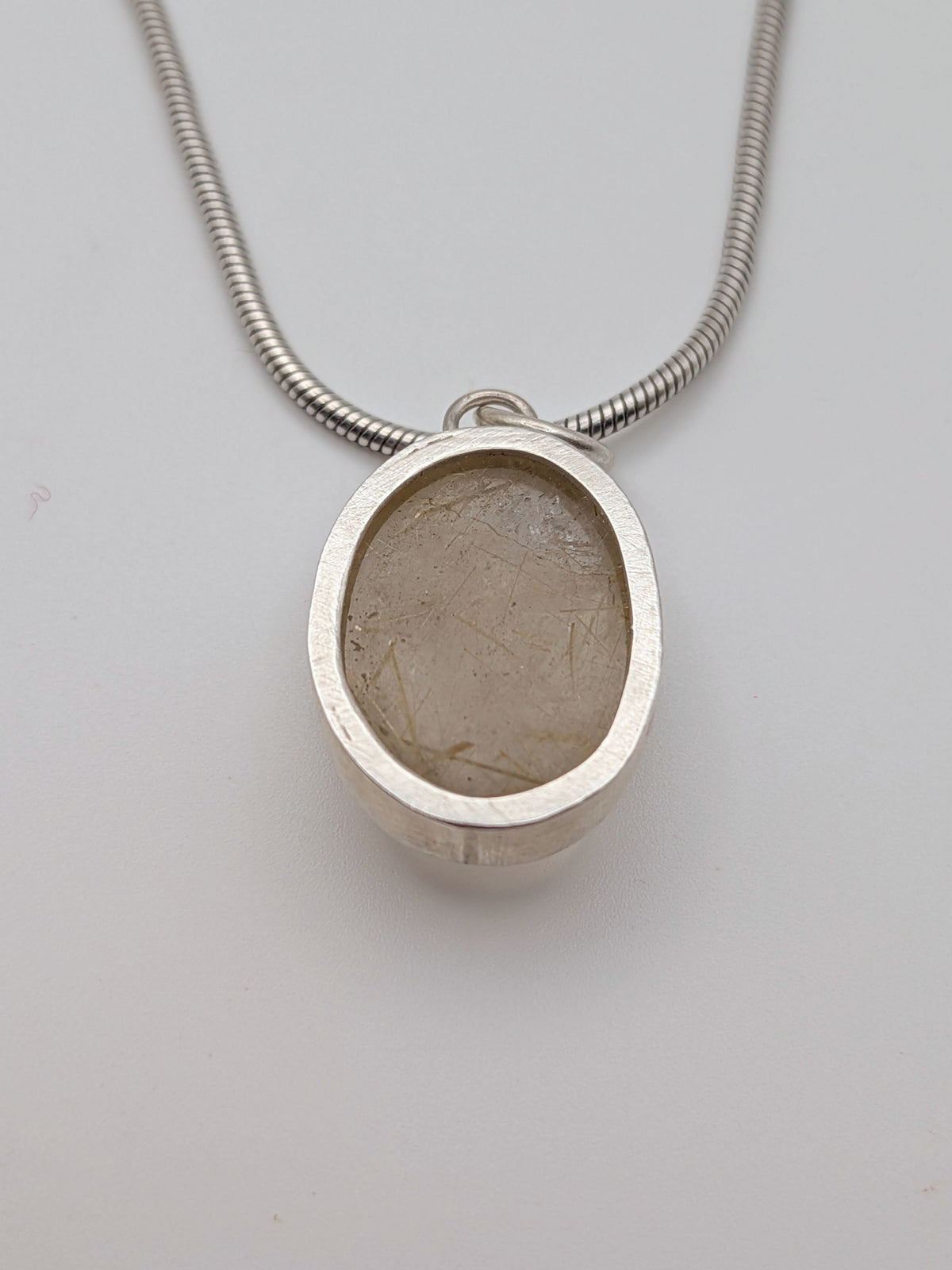Rutilated quartz pendant in a handmade sterling silver setting by All Our Light.